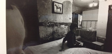 Old picture of a person in their dark bedsit 