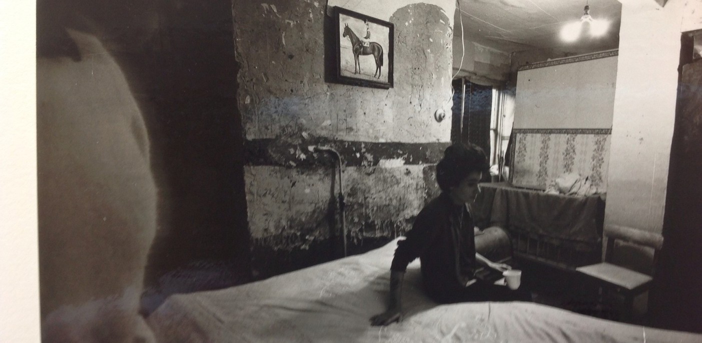 Old picture of a person in their dark bedsit 