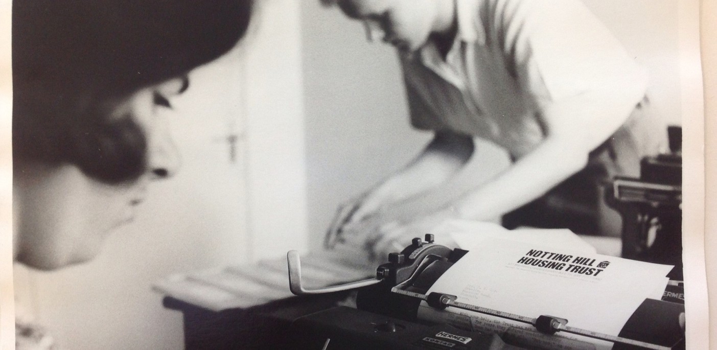 Old black and white picture showing a Notting Hill housing newsletter being typed. 
