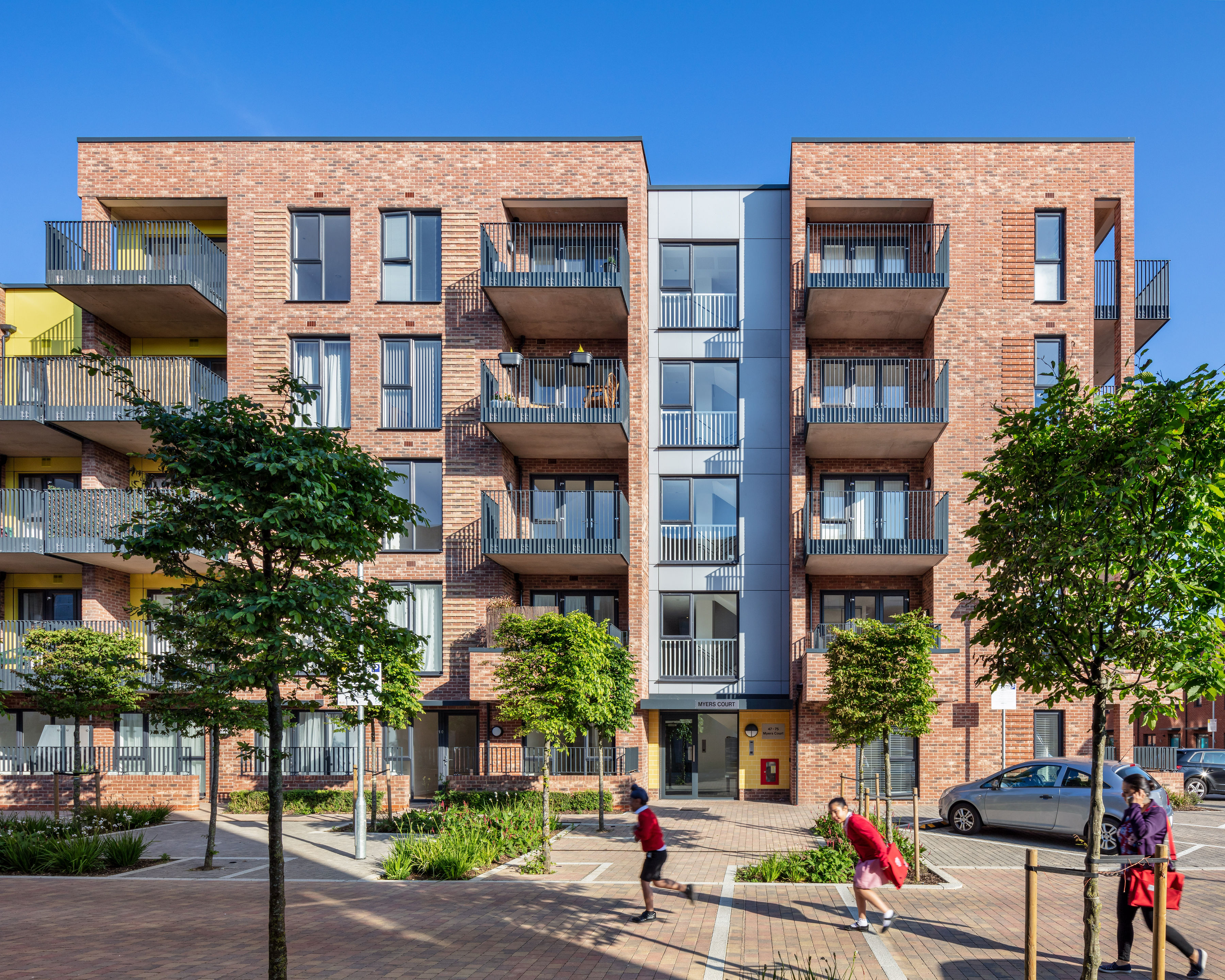 Kids running in front of a housing building