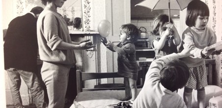 Old black and white picture showing a young family in a Notting Hill housing bedroom. 