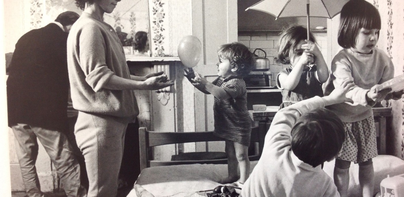 Old black and white picture showing a young family in a Notting Hill housing bedroom. 