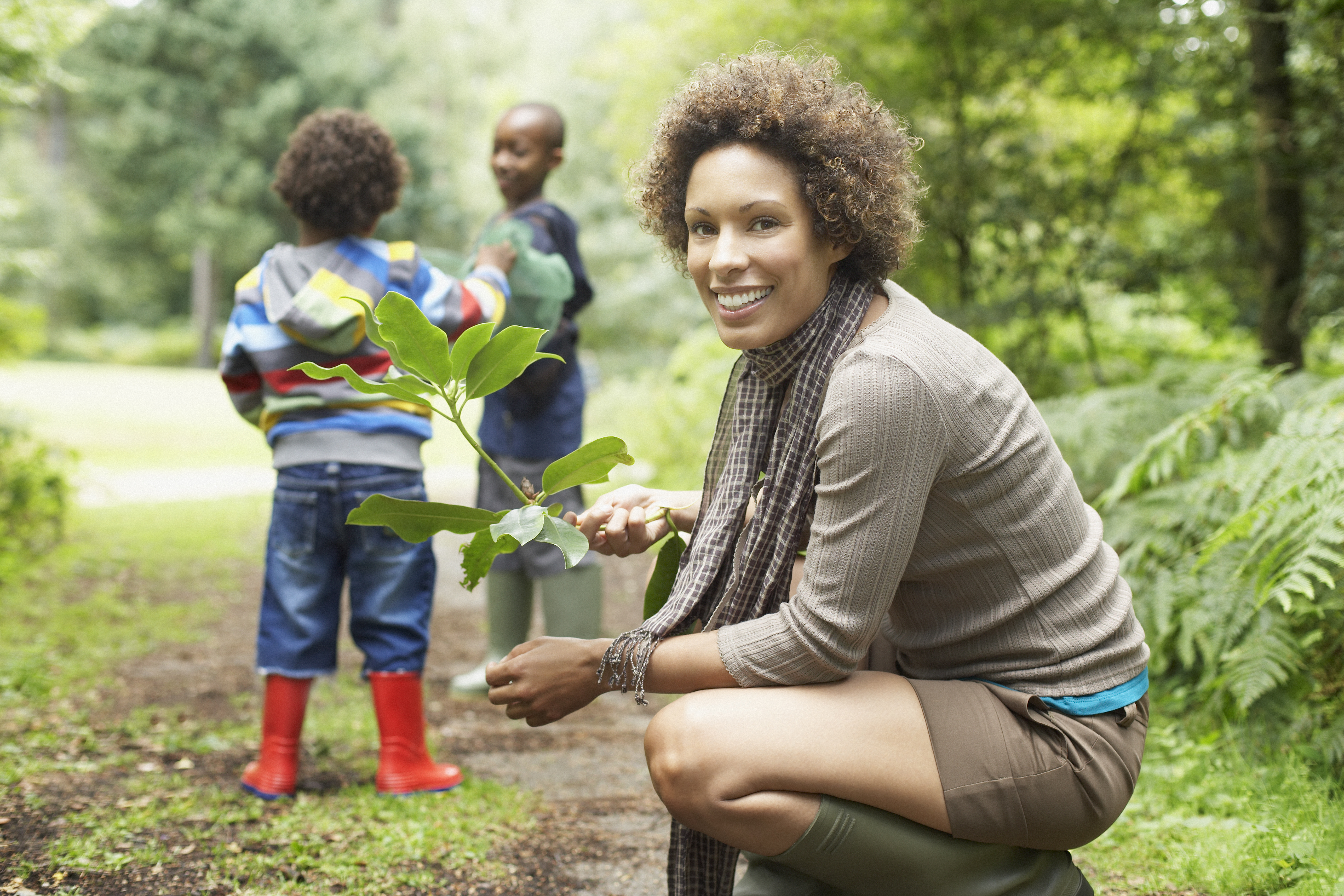 A lady in a park with children. 